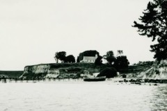 Matakana Island wharf with St Joseph's Catholic Church visible on the hill, 1951.