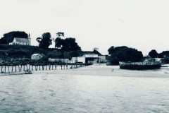 Matakana Island wharf with St Joseph's Catholic Church visible on the hill, 1951.